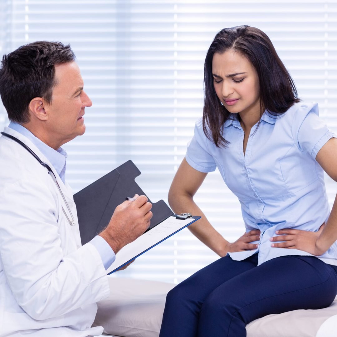 Patient suffering from stomach ache while consulting doctor Patient suffering from stomach ache while consulting doctor in clinic